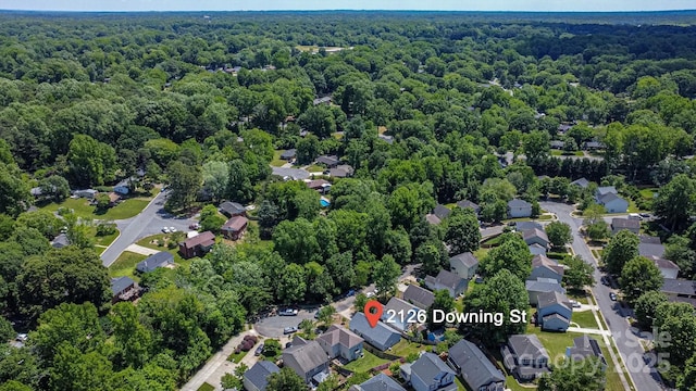 aerial overview of property's location featuring a forest and nearby suburban area