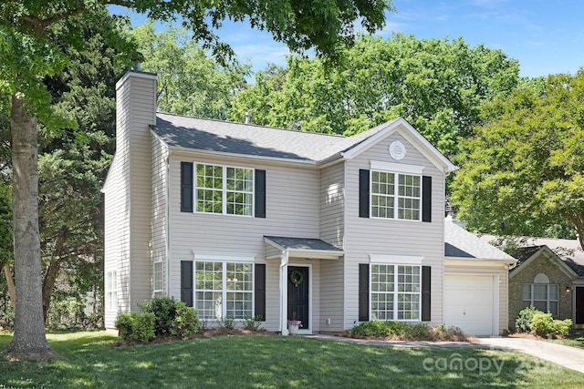 view of front of house with a garage, a front lawn, a chimney, and concrete driveway