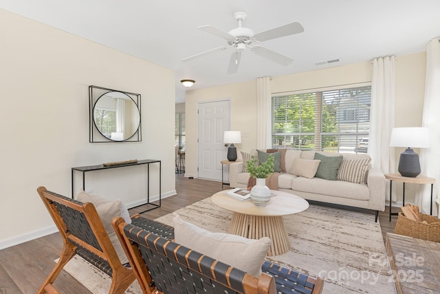 living area featuring baseboards, a ceiling fan, wood finished floors, and visible vents