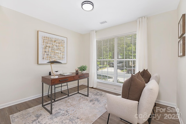 home office with baseboards, wood finished floors, and visible vents