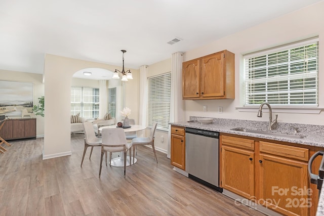 kitchen featuring a sink, light wood-style floors, an inviting chandelier, and stainless steel dishwasher