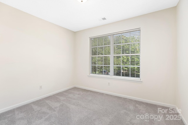 empty room featuring baseboards, carpet flooring, and visible vents