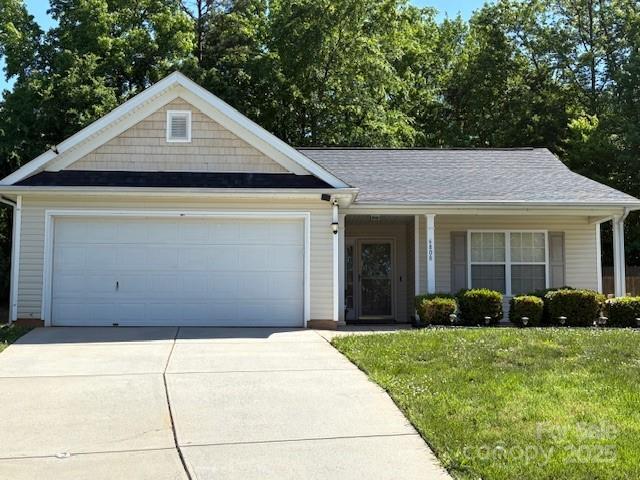 6808 Squirrels Foot Ct, Charlotte, NC 28217 - view of front facade with covered porch, a garage, a front yard, and driveway