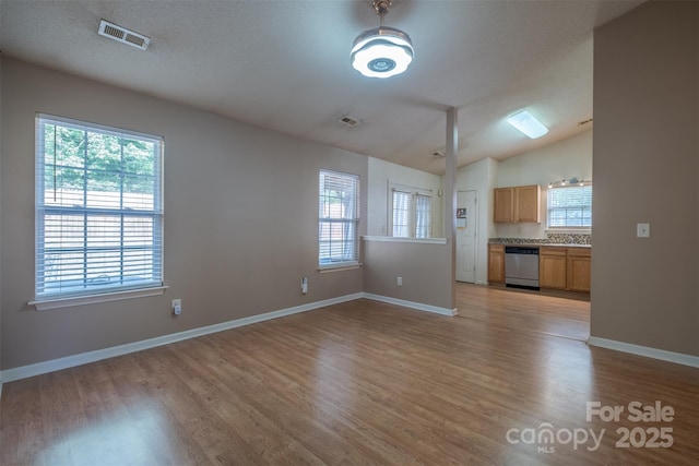 6808 Squirrels Foot Ct, Charlotte, NC 28217 - unfurnished living room featuring baseboards, light wood-style flooring, visible vents, and vaulted ceiling