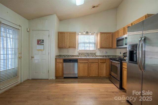 6808 Squirrels Foot Ct, Charlotte, NC 28217 - kitchen with a sink, stainless steel appliances, visible vents, vaulted ceiling, and light wood-style flooring