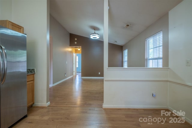 6808 Squirrels Foot Ct, Charlotte, NC 28217 - kitchen with freestanding refrigerator, lofted ceiling, baseboards, and light wood-type flooring