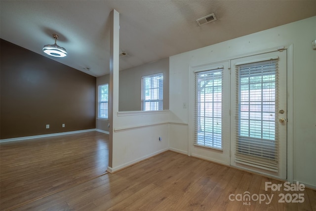 6808 Squirrels Foot Ct, Charlotte, NC 28217 - unfurnished room with lofted ceiling, baseboards, visible vents, and wood finished floors