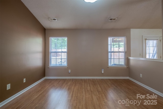 6808 Squirrels Foot Ct, Charlotte, NC 28217 - spare room with baseboards, visible vents, and wood finished floors