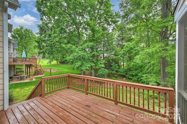 deck featuring a lawn, stairs, and a patio
