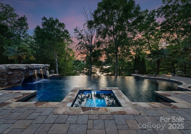 172 Tennessee Cir, Mooresville, NC 28117 - pool at dusk featuring a pool with connected hot tub and a patio
