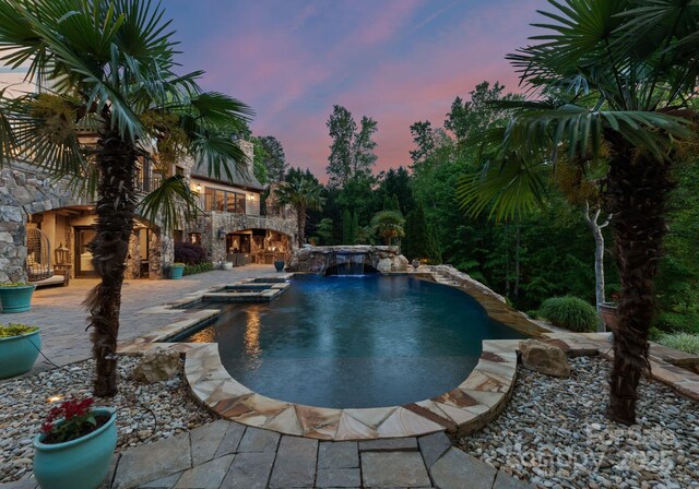 172 Tennessee Cir, Mooresville, NC 28117 - pool at dusk featuring a patio area and a pool with connected hot tub