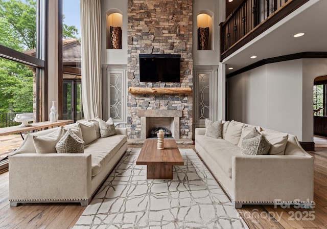 172 Tennessee Cir, Mooresville, NC 28117 - living area with a stone fireplace, a high ceiling, wood finished floors, ornamental molding, and recessed lighting