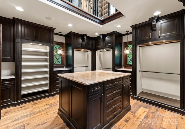 172 Tennessee Cir, Mooresville, NC 28117 - kitchen featuring light stone counters, light wood-style floors, crown molding, recessed lighting, and a center island