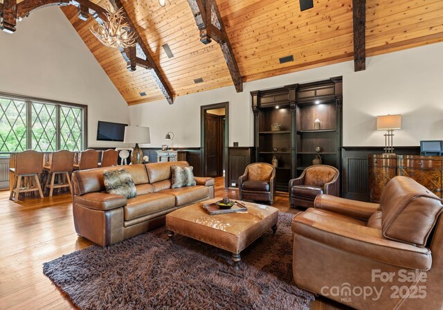 172 Tennessee Cir, Mooresville, NC 28117 - living room featuring wooden ceiling with exposed beams, wood-type flooring, a chandelier, high vaulted ceiling, and wainscoting