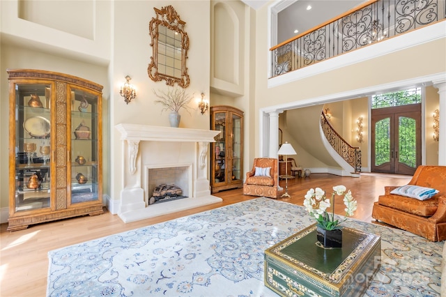 8451 Ridgewood Rd, Sherrills Ford, NC 28673 - living room featuring decorative columns, french doors, a towering ceiling, wood finished floors, and baseboards