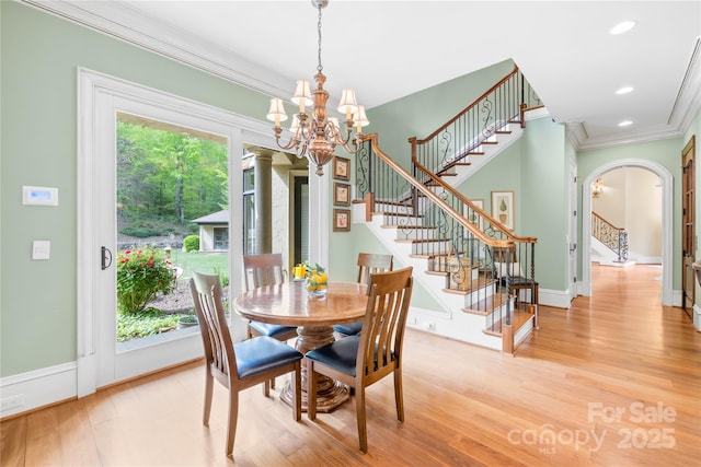 8451 Ridgewood Rd, Sherrills Ford, NC 28673 - dining room with crown molding, arched walkways, wood finished floors, stairway, and an inviting chandelier