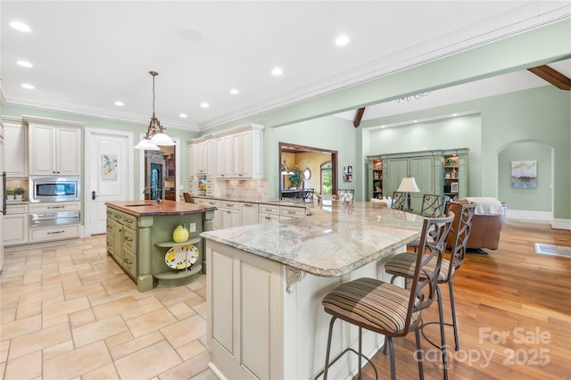 8451 Ridgewood Rd, Sherrills Ford, NC 28673 - kitchen featuring backsplash, a sink, stainless steel microwave, a warming drawer, and an island with sink