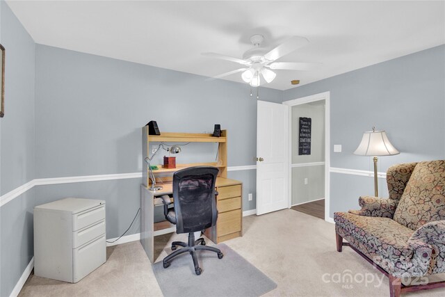office area featuring baseboards, ceiling fan, and carpet
