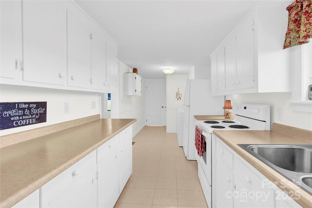 kitchen featuring light countertops, light tile patterned floors, white electric range, and white cabinetry