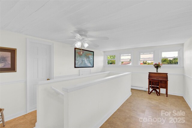 hallway with light tile patterned floors, baseboards, and baseboard heating