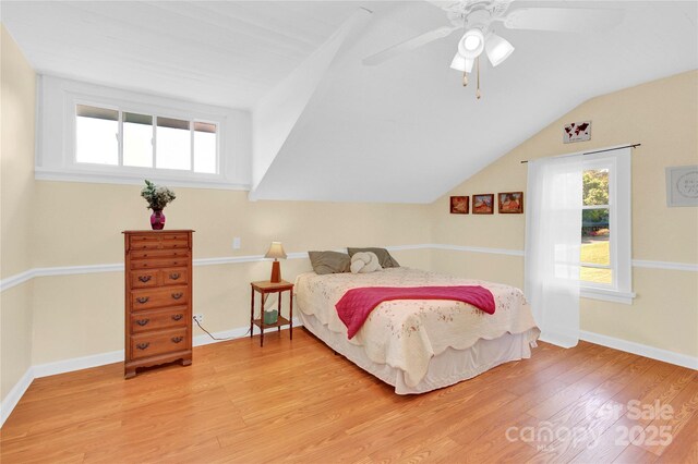 bedroom with baseboards, ceiling fan, light wood-type flooring, and lofted ceiling