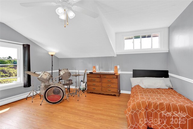 bedroom featuring baseboards, a ceiling fan, wood finished floors, and vaulted ceiling