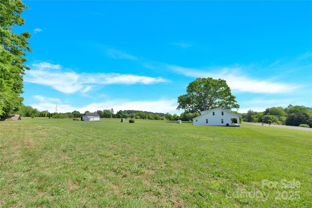 view of yard with a rural view and an outdoor structure