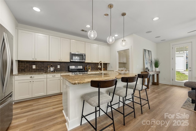 2638 Double Oaks Rd, Charlotte, NC 28206 - kitchen featuring appliances with stainless steel finishes, a sink, backsplash, light wood-style flooring, and recessed lighting
