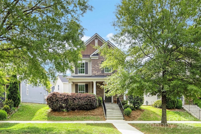 2638 Double Oaks Rd, Charlotte, NC 28206 - view of front of property with stairway, brick siding, a front yard, and covered porch