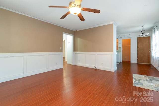 1108 Old Dallas Hwy, Dallas, NC 28034 - unfurnished room with crown molding, wainscoting, wood finished floors, ceiling fan with notable chandelier, and a decorative wall