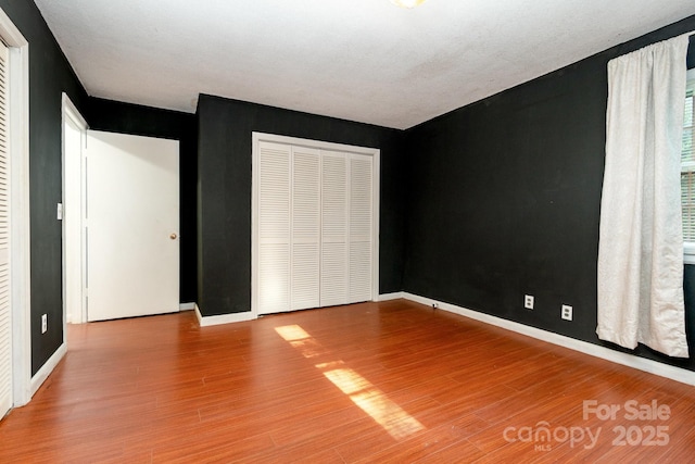 1108 Old Dallas Hwy, Dallas, NC 28034 - unfurnished bedroom featuring baseboards, a closet, and wood finished floors