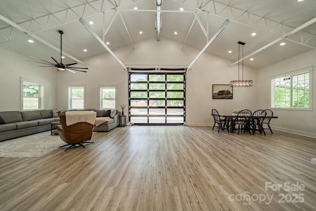 living area with high vaulted ceiling, plenty of natural light, baseboards, and beam ceiling