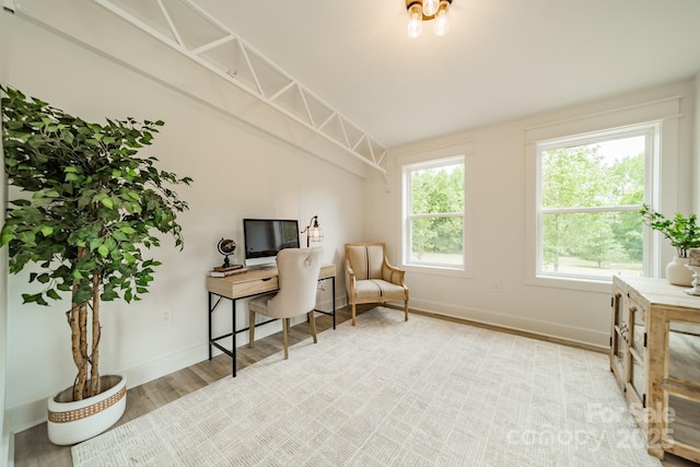 living area with baseboards, wood finished floors, and vaulted ceiling
