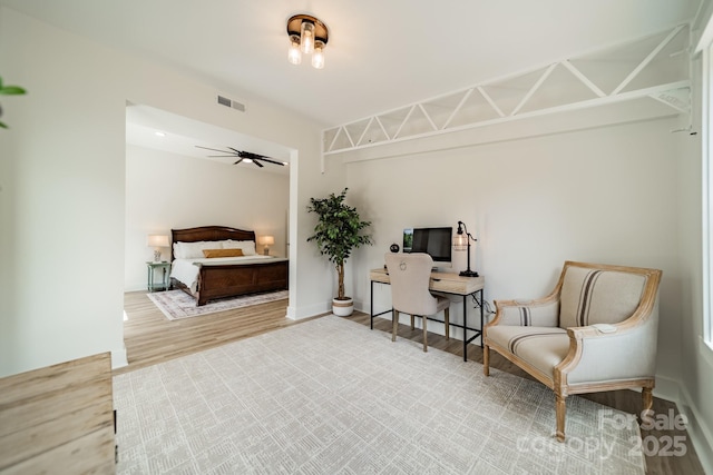 bedroom featuring baseboards, visible vents, and wood finished floors