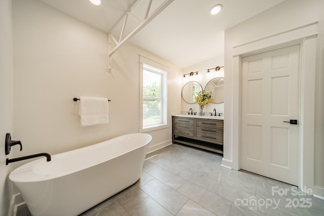full bath featuring a freestanding tub, vanity, baseboards, marble finish floor, and recessed lighting