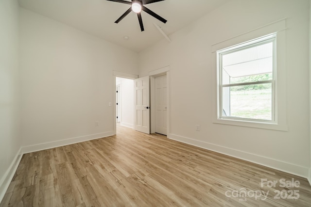unfurnished room with light wood-style floors, baseboards, and ceiling fan