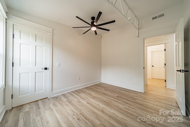 unfurnished bedroom featuring baseboards, ceiling fan, light wood-style flooring, and visible vents