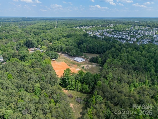 bird's eye view with a wooded view