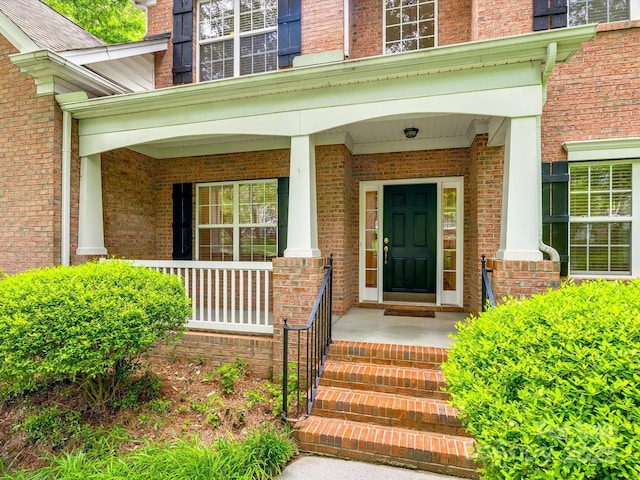 entrance to property with brick siding and covered porch