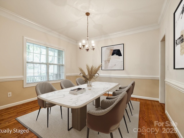 dining area with baseboards, a chandelier, ornamental molding, and wood finished floors