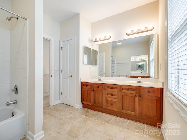 full bathroom with double vanity, a sink, baseboards, and tile patterned flooring