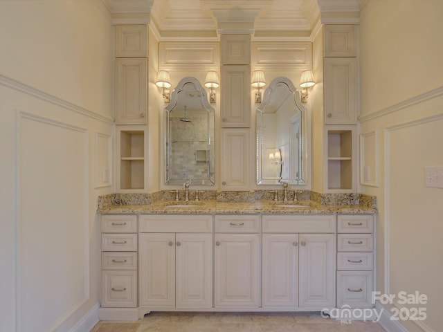 bathroom with a sink, built in features, crown molding, and double vanity