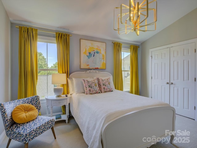 bedroom with a closet, vaulted ceiling, carpet flooring, and a chandelier