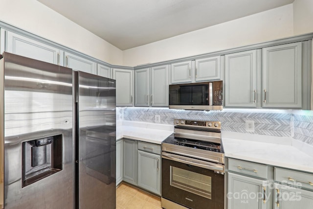 8259 Carob Tree Ln, Charlotte, NC 28215 - kitchen with stainless steel appliances, gray cabinetry, light countertops, and light tile patterned flooring