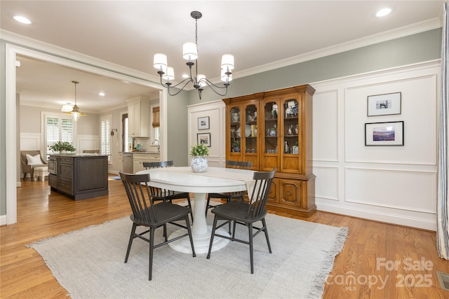 1517 Waverly Ave, Charlotte, NC 28203 - dining space featuring a decorative wall, a chandelier, crown molding, light wood-style flooring, and recessed lighting