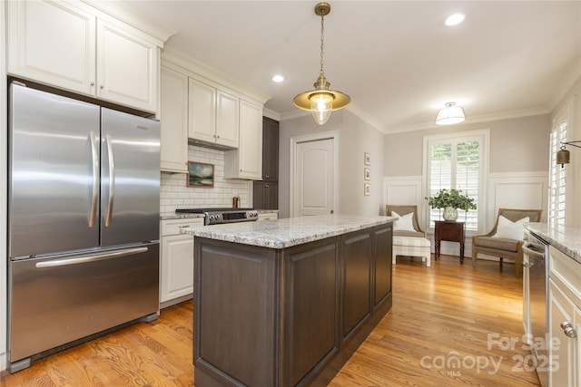 1517 Waverly Ave, Charlotte, NC 28203 - kitchen with appliances with stainless steel finishes, light wood-type flooring, pendant lighting, white cabinetry, and crown molding