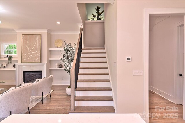 116 S Broad St, Waxhaw, NC 28173 - stairs with a premium fireplace, recessed lighting, baseboards, wood finished floors, and ornamental molding