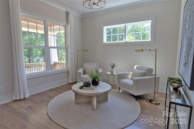 116 S Broad St, Waxhaw, NC 28173 - living area featuring baseboards, crown molding, wood finished floors, and an inviting chandelier