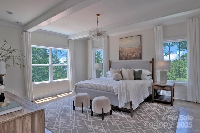 116 S Broad St, Waxhaw, NC 28173 - bedroom featuring an inviting chandelier, beam ceiling, wood finished floors, and multiple windows