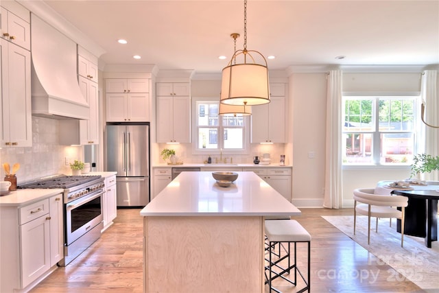 116 S Broad St, Waxhaw, NC 28173 - kitchen featuring a breakfast bar, a center island, light wood-type flooring, a sink, and premium appliances